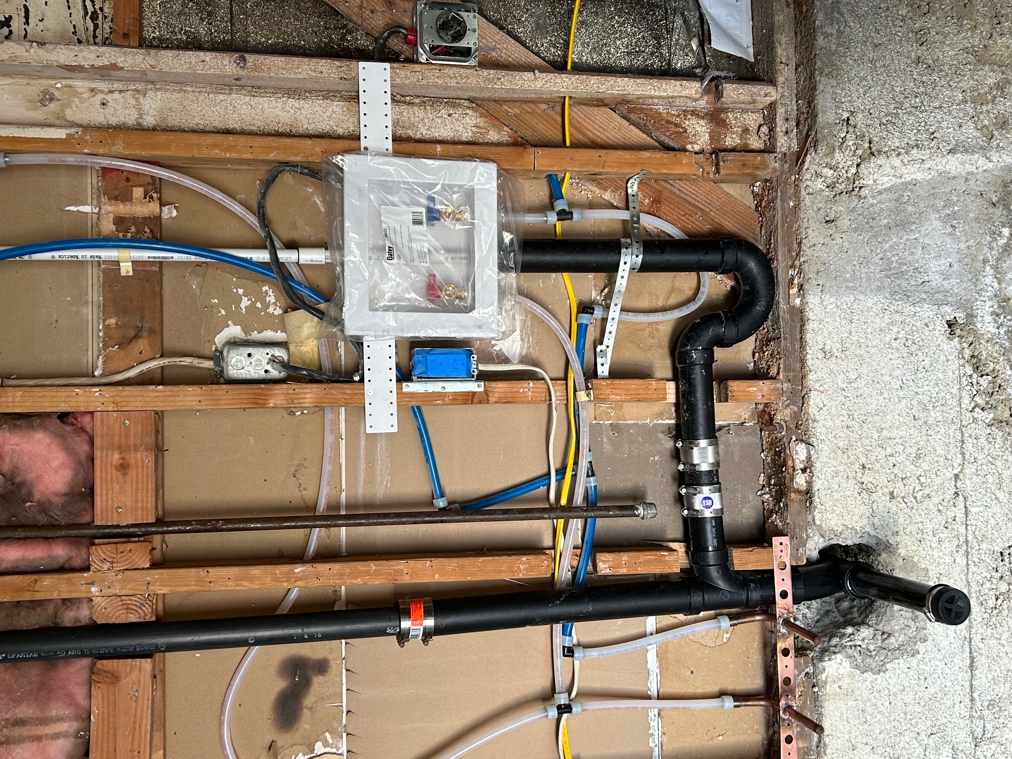 New water and drain lines in an open wall during a remodel